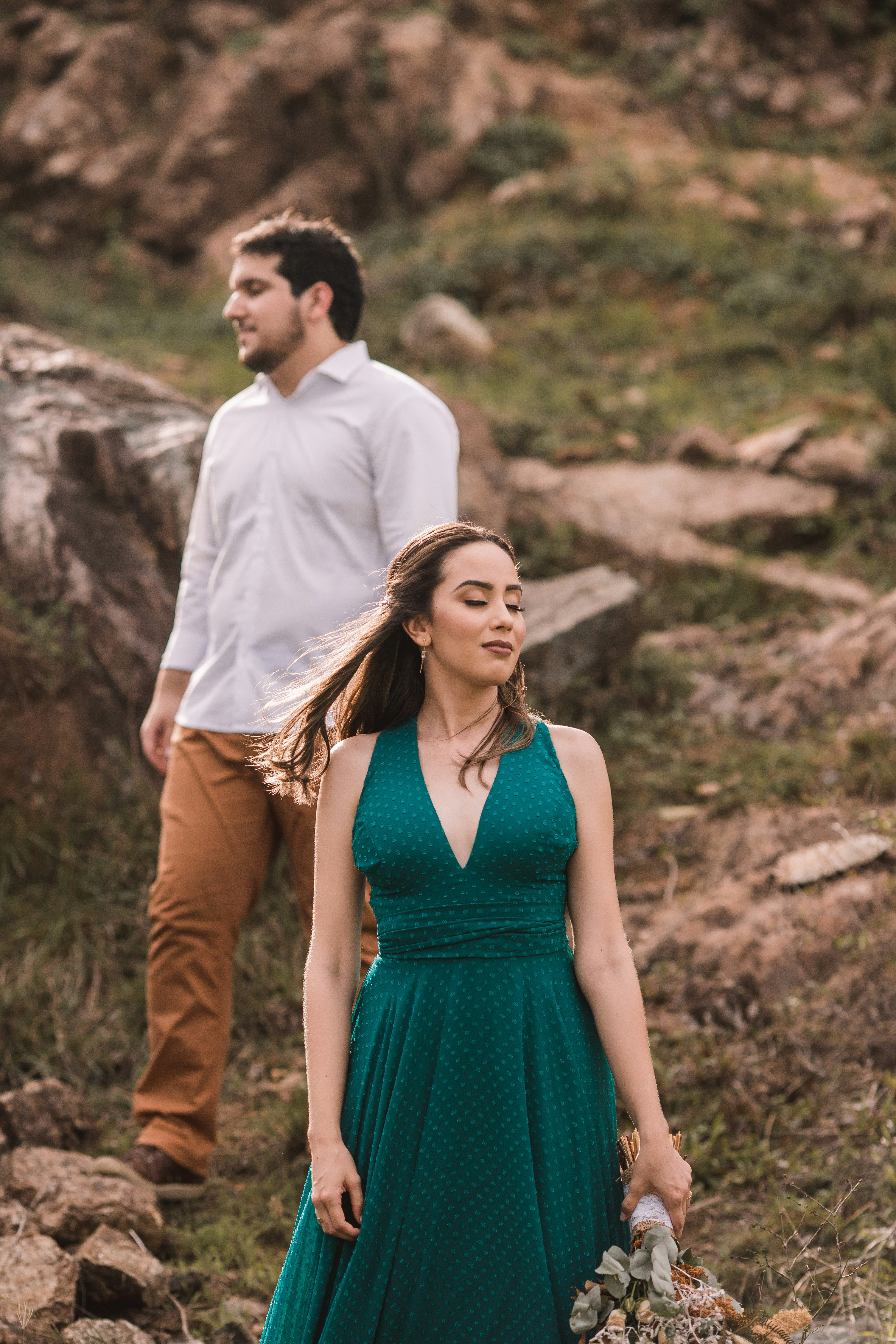 man and woman standing on brown field during daytime